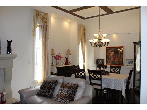 A living room with a grey couch and a chandelier.