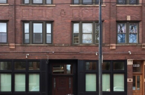 A red brick building with a black door and windows.