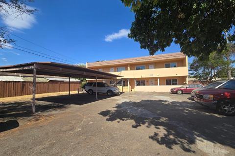 A parking lot with cars and a building in the background.