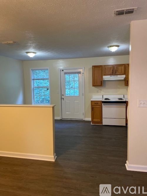 A kitchen with a white fridge, dishwasher and oven, and wooden cabinets.