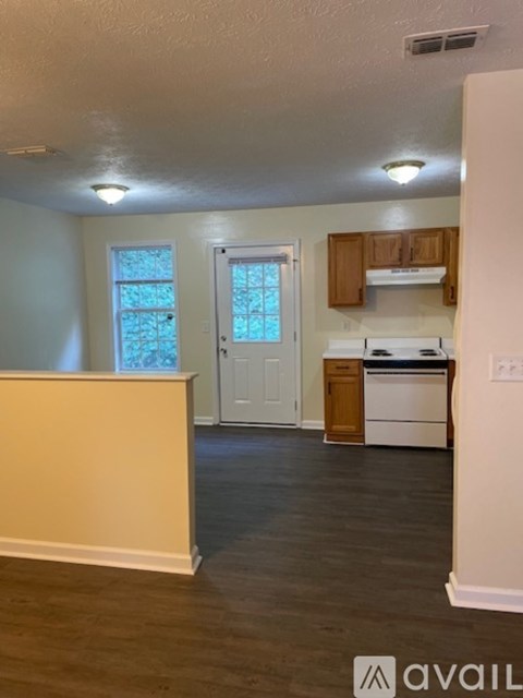 A kitchen with a white fridge, dishwasher and oven, and wooden cabinets.