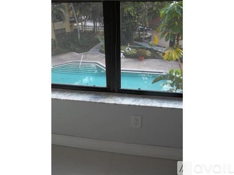 A window with a view of a pool and a residential area.