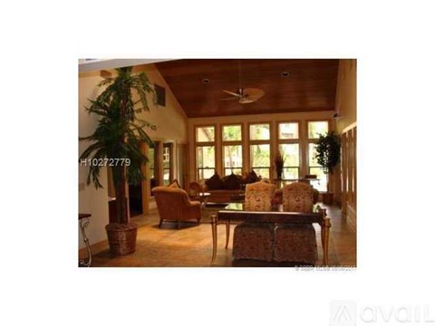 A living room with a ceiling fan and a large window.
