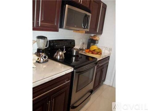A kitchen with a black stove top and a black microwave above it.