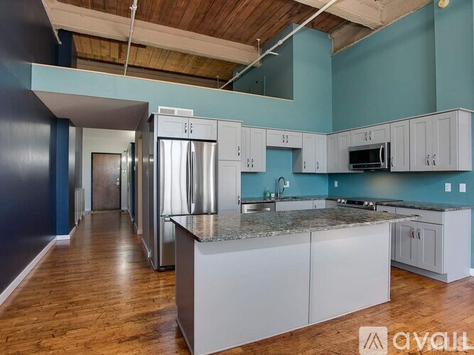 A kitchen with a refrigerator, microwave, and cabinets.