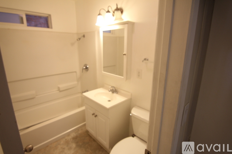 A bathroom with a toilet, sink and bathtub.