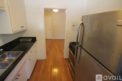 A kitchen with a stainless steel refrigerator and wooden floors.