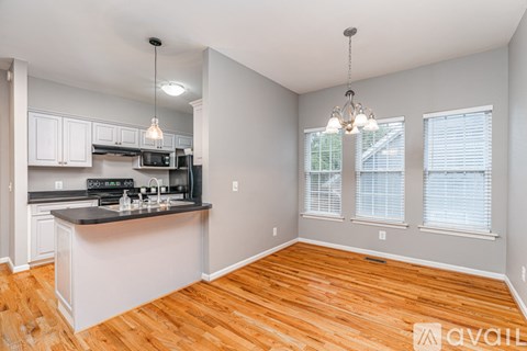 A kitchen with white cabinets and a black countertop.