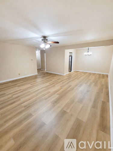 A room with wooden flooring and a ceiling fan.