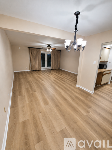 A room with wooden flooring and a chandelier.
