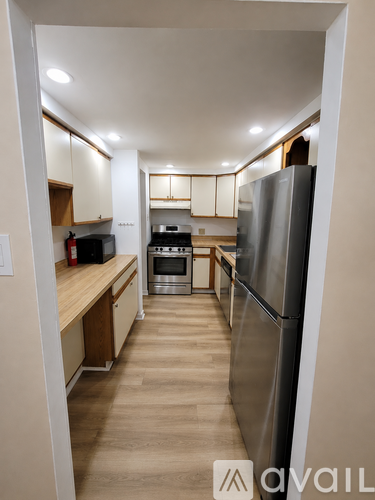 A kitchen with a refrigerator, oven, and microwave.