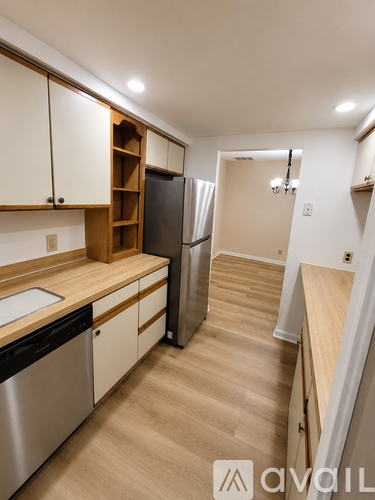 A kitchen with wooden cabinets and a refrigerator.