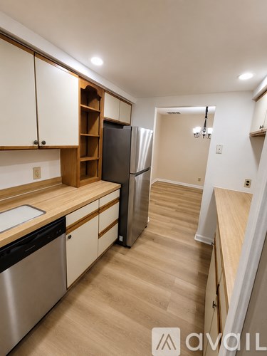 A kitchen with wooden cabinets and a refrigerator.