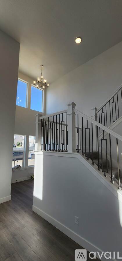 A well-lit, spacious interior with a staircase and a chandelier.