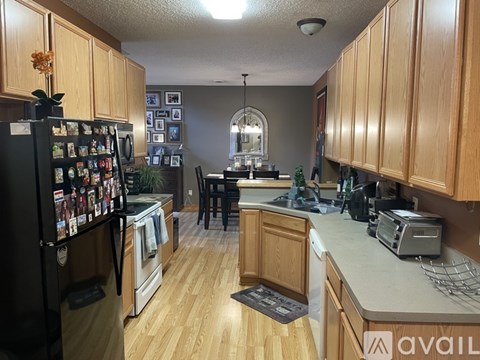 A kitchen with wooden cabinets and a black fridge.
