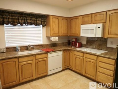 A kitchen with wooden cabinets and a white dishwasher.