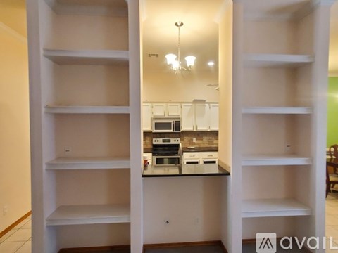 A kitchen with a white countertop and cabinets is available for rent.