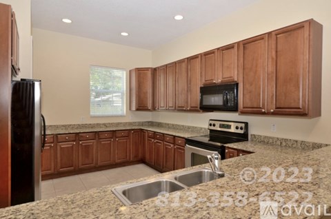 A kitchen with brown cabinets and granite countertops.