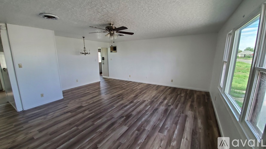 A room with wooden flooring and a ceiling fan.