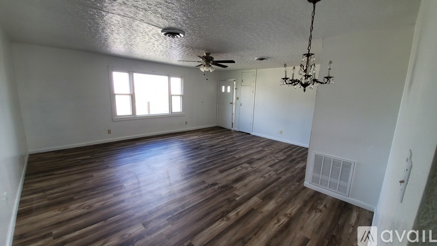 A room with wooden floors and a chandelier.