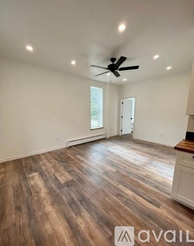 A room with wooden flooring and a ceiling fan.