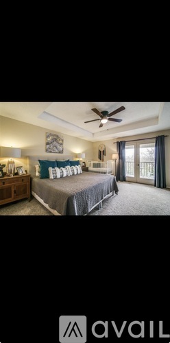 A bedroom with a large bed and a ceiling fan.