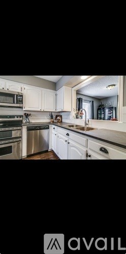 A modern kitchen with white cabinets and stainless steel appliances.