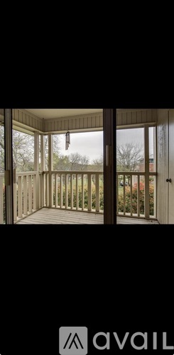 A balcony with a view of trees and a building.