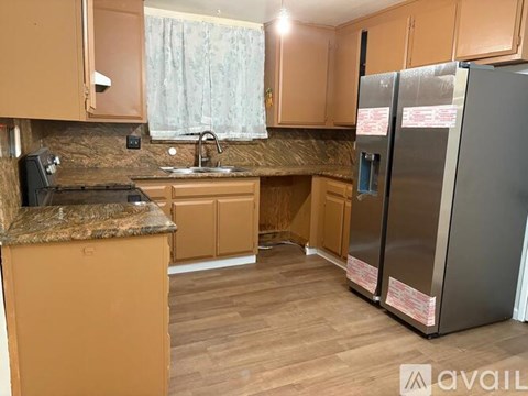 A kitchen with wooden cabinets and a granite countertop.