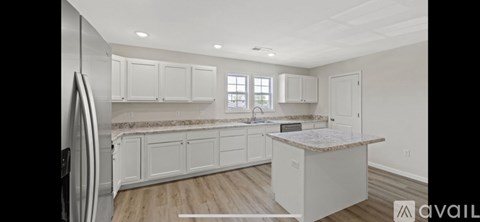 A kitchen with white cabinets and a central island.