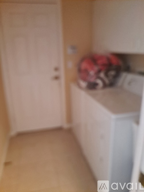 A white washing machine in a room with a door.