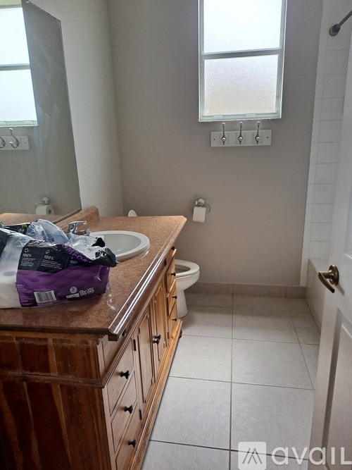 A bathroom with a toilet, sink, and a window.