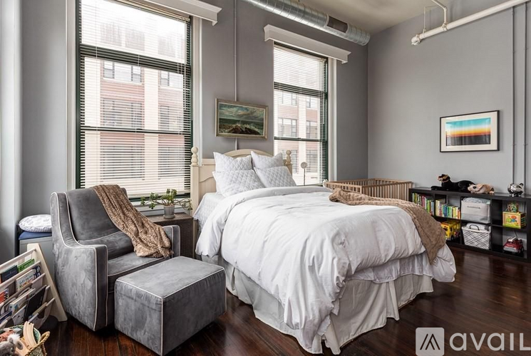 A bedroom with a large bed and a chair.
