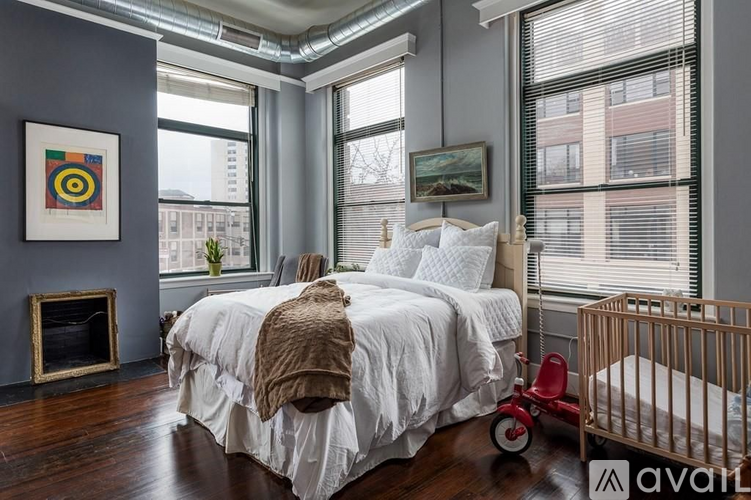 A bedroom with a white bed and a red tricycle.