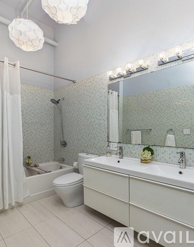 A bathroom with a toilet, sink, and shower.