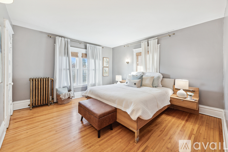 A bedroom with a large bed and a wooden bench.