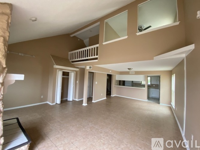 A spacious living room with a large window and a flat screen TV.