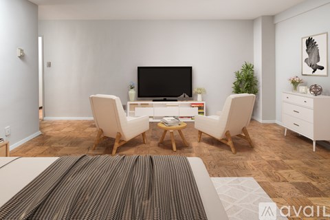 A living room with a television, two chairs, and a coffee table.