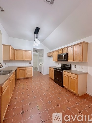 A kitchen with wooden cabinets and a tiled floor.
