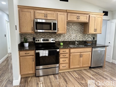 A kitchen with wooden cabinets and a black stove top oven.