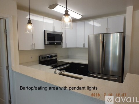 A kitchen with a refrigerator, microwave, and oven.