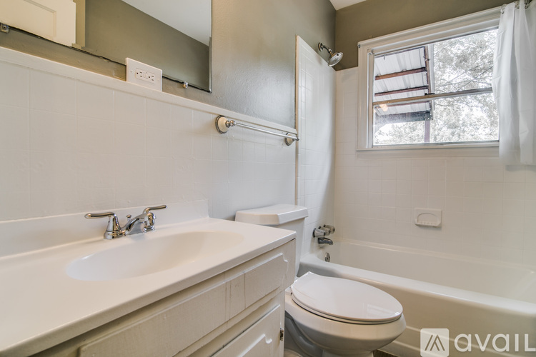 A bathroom with a white sink, toilet, and bathtub.