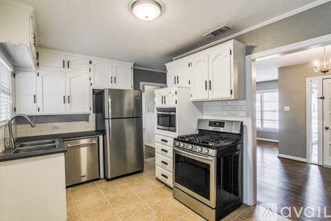 A kitchen with white cabinets and stainless steel appliances.
