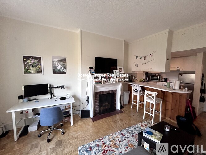 A living room with a fireplace and a dining area with a table and chairs.