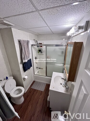 A small, clean bathroom with a toilet, sink, and shower.