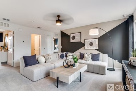 A modern living room with a white sofa and a coffee table.