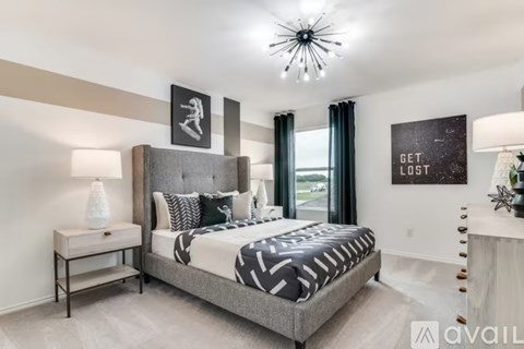 A bedroom with a large bed and a chandelier.
