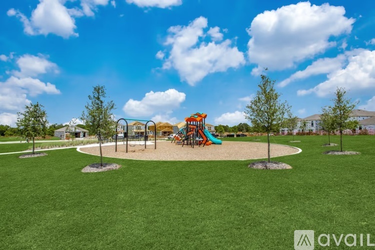 A playground with a slide and swings under a blue sky.