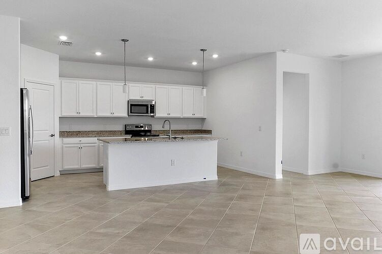 A kitchen with white cabinets and appliances is available for rent.
