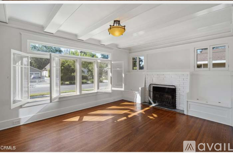 A spacious living room with a fireplace and large windows.